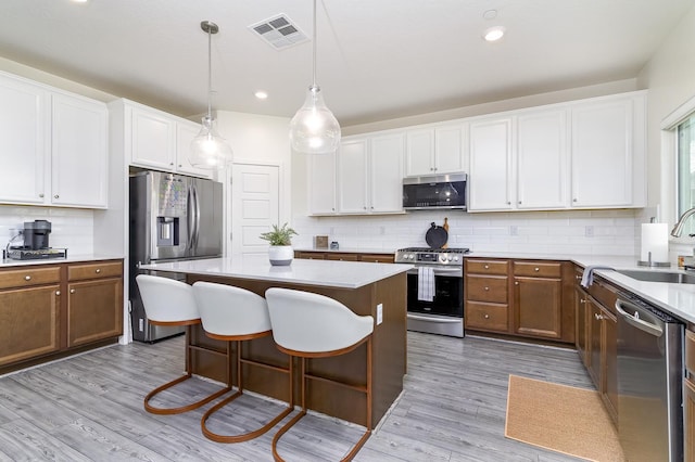 165 Timberline Way S, Madera, CA 93636 - kitchen featuring stainless steel appliances, a center island, white cabinetry, decorative backsplash, and recessed lighting