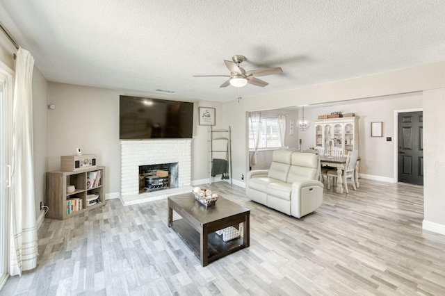 447 W Scott Ave, Clovis, CA 93612 - living room with a ceiling fan, a textured ceiling, light wood finished floors, and a fireplace