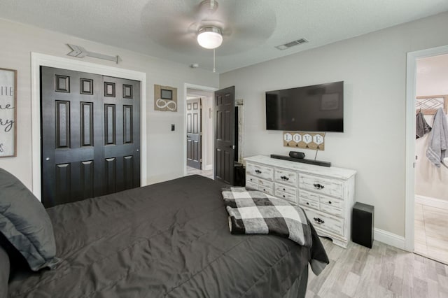 447 W Scott Ave, Clovis, CA 93612 - bedroom with a closet, a textured ceiling, ceiling fan, and light wood-style floors