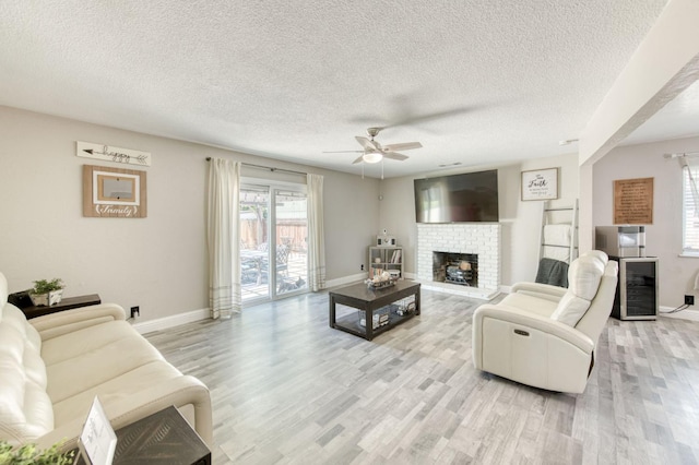 447 W Scott Ave, Clovis, CA 93612 - living area with wine cooler, light wood-style flooring, a ceiling fan, a textured ceiling, and a fireplace