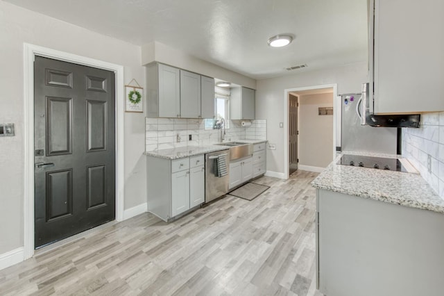 447 W Scott Ave, Clovis, CA 93612 - kitchen featuring stainless steel dishwasher, decorative backsplash, black electric cooktop, light wood-type flooring, and gray cabinetry