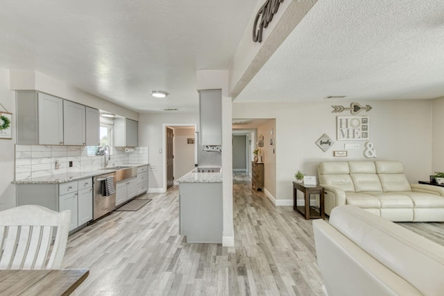 447 W Scott Ave, Clovis, CA 93612 - kitchen with dishwasher, gray cabinets, open floor plan, light wood-style flooring, and light stone counters