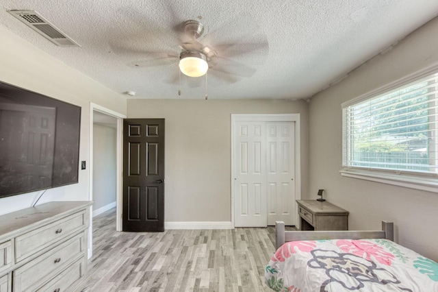 447 W Scott Ave, Clovis, CA 93612 - bedroom featuring light wood-type flooring, a textured ceiling, a closet, and ceiling fan