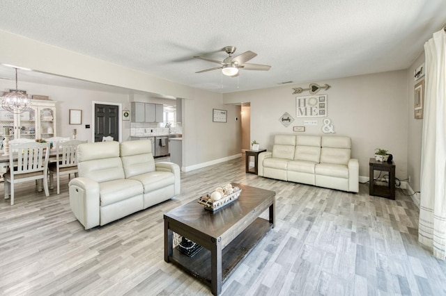 447 W Scott Ave, Clovis, CA 93612 - living area with light wood finished floors, a ceiling fan, a textured ceiling, and a chandelier