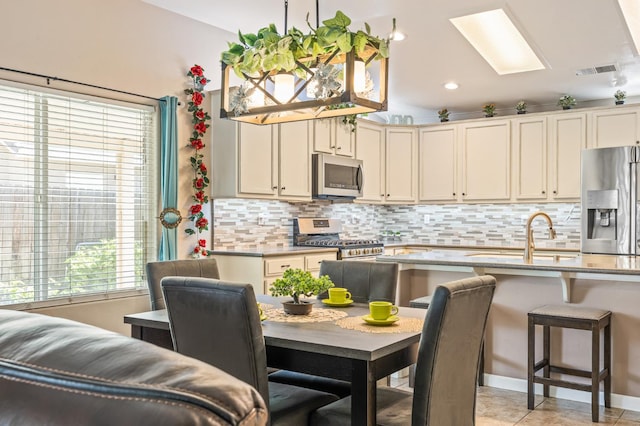 3624 N Jackie, Visalia, CA 93291 - kitchen featuring appliances with stainless steel finishes, backsplash, recessed lighting, pendant lighting, and cream cabinets