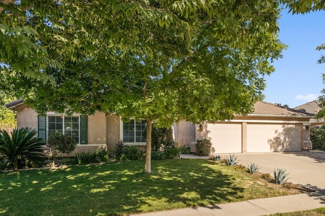 3624 N Jackie, Visalia, CA 93291 - obstructed view of property featuring stucco siding, an attached garage, driveway, and a front lawn