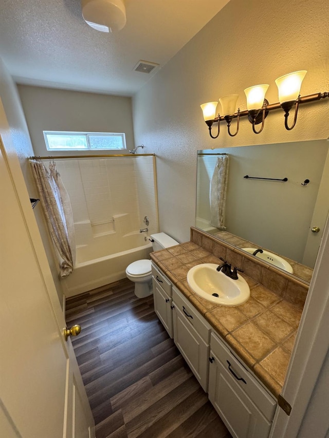2428 E Emilie Ave, Fresno, CA 93730 - full bathroom with wood finished floors, vanity, shower / bath combo, and a textured wall