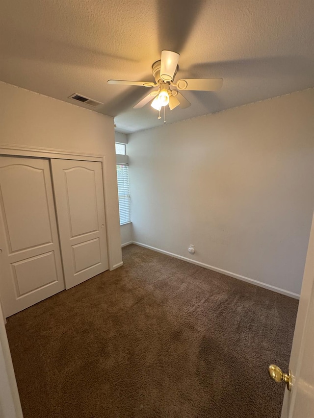 2428 E Emilie Ave, Fresno, CA 93730 - unfurnished bedroom featuring dark carpet, a closet, a textured ceiling, and a ceiling fan