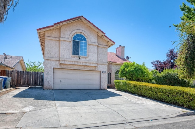 3340 N Dante Ave, Fresno, CA 93722 - mediterranean / spanish-style home featuring an attached garage, concrete driveway, a chimney, a tile roof, and stucco siding