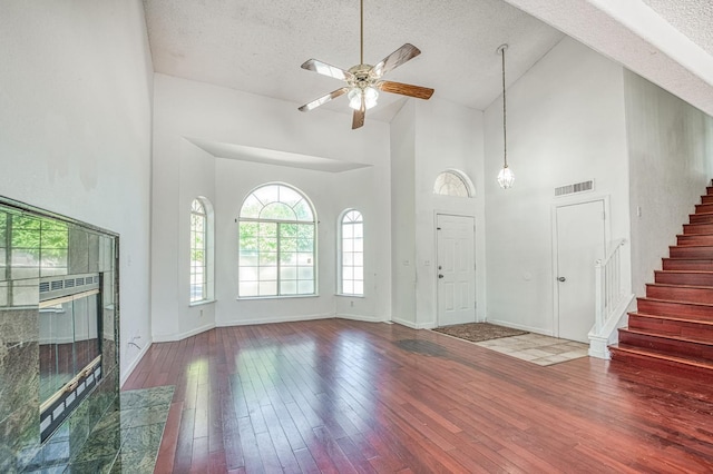 3340 N Dante Ave, Fresno, CA 93722 - unfurnished living room featuring high vaulted ceiling, a textured ceiling, stairway, wood-type flooring, and ceiling fan