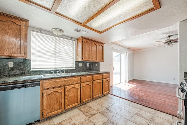 3340 N Dante Ave, Fresno, CA 93722 - kitchen featuring dishwasher, brown cabinetry, decorative backsplash, dark countertops, and a ceiling fan