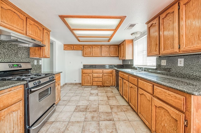 3340 N Dante Ave, Fresno, CA 93722 - kitchen with stainless steel gas range, under cabinet range hood, backsplash, brown cabinets, and dishwasher