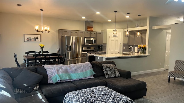 2434 Cherrywood Ct, Hanford, CA 93230 - living room featuring wood finished floors, a chandelier, and recessed lighting