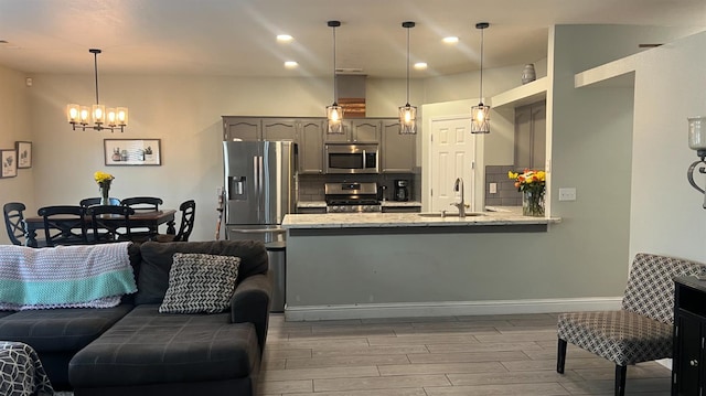 2434 Cherrywood Ct, Hanford, CA 93230 - kitchen with appliances with stainless steel finishes, a chandelier, gray cabinets, backsplash, and light wood-type flooring