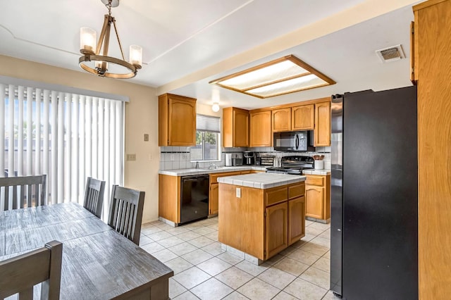 2687 Fowler Ave, Clovis, CA 93611 - kitchen with black appliances, a kitchen island, tasteful backsplash, tile counters, and light tile patterned flooring