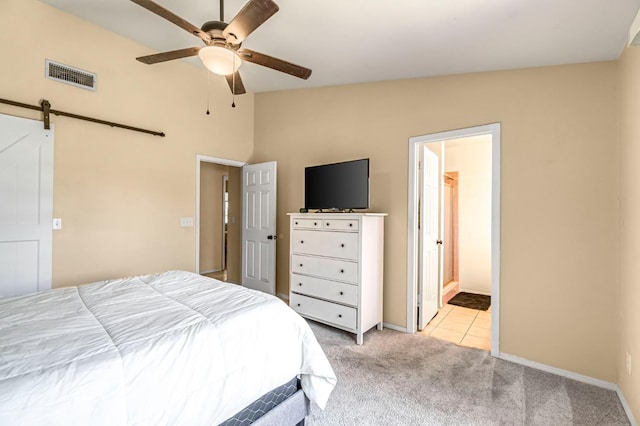 2687 Fowler Ave, Clovis, CA 93611 - bedroom with a barn door, light carpet, ensuite bathroom, vaulted ceiling, and ceiling fan