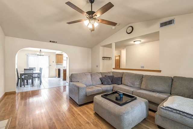 2687 Fowler Ave, Clovis, CA 93611 - living area featuring arched walkways, a chandelier, light wood-style floors, vaulted ceiling, and ceiling fan