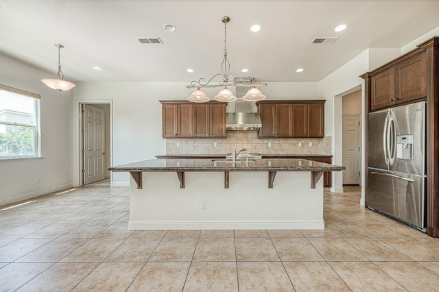 2593 E Utah, Fresno, CA 93720 - kitchen featuring stainless steel refrigerator with ice dispenser, light tile patterned floors, wall chimney range hood, dark stone countertops, and recessed lighting