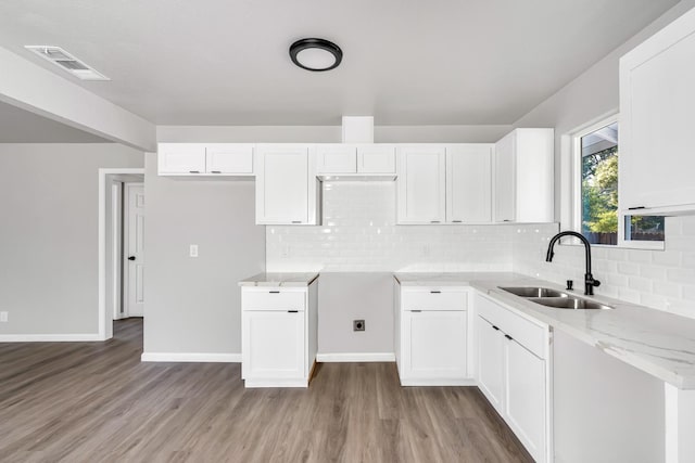1934 W Pontiac Way, Fresno, CA 93705 - kitchen with light wood-style flooring, white cabinets, light stone countertops, and backsplash