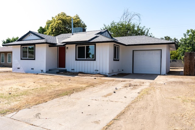 1934 W Pontiac Way, Fresno, CA 93705 - view of front facade with a garage, concrete driveway, a shingled roof, roof mounted solar panels, and crawl space