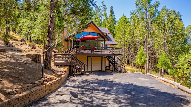 53608 Chipo Poyah, North Fork, CA 93643 - view of front of house featuring stairway, driveway, a deck, an attached garage, and a chimney