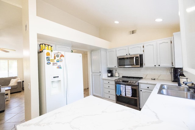 5263 W Griffith Way, Fresno, CA 93722 - kitchen with appliances with stainless steel finishes, tasteful backsplash, light stone counters, a peninsula, and vaulted ceiling