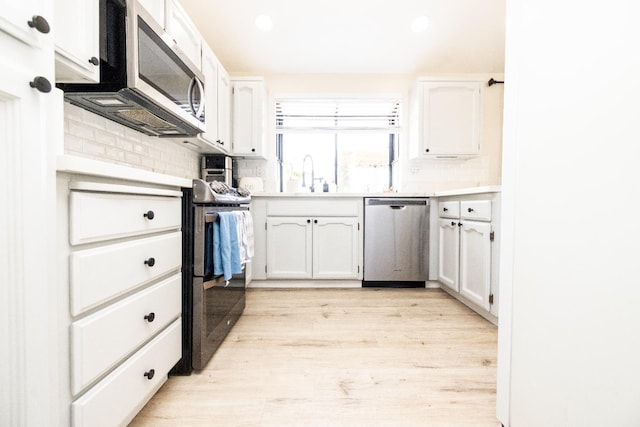 5263 W Griffith Way, Fresno, CA 93722 - kitchen with appliances with stainless steel finishes, white cabinets, decorative backsplash, light wood finished floors, and recessed lighting