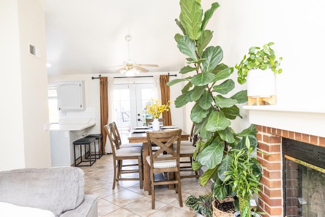 5263 W Griffith Way, Fresno, CA 93722 - dining space featuring light tile patterned floors, a fireplace, a ceiling fan, and french doors