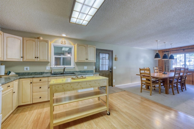 42055 Saddleback Rd, Shaver Lake, CA 93664 - kitchen with light brown cabinetry, a textured ceiling, dark countertops, and light wood-style floors