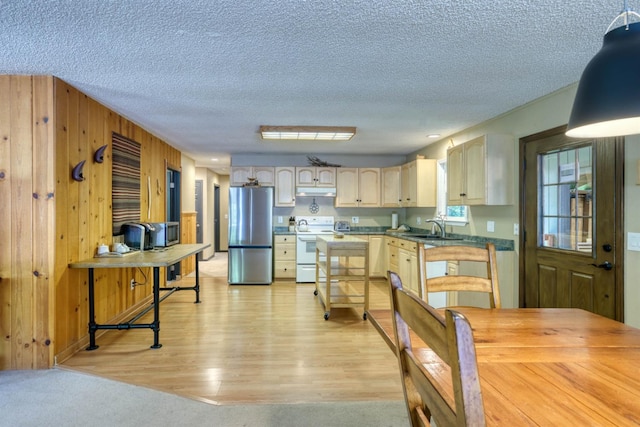 42055 Saddleback Rd, Shaver Lake, CA 93664 - kitchen with appliances with stainless steel finishes, light wood-style flooring, a textured ceiling, dark countertops, and wood walls