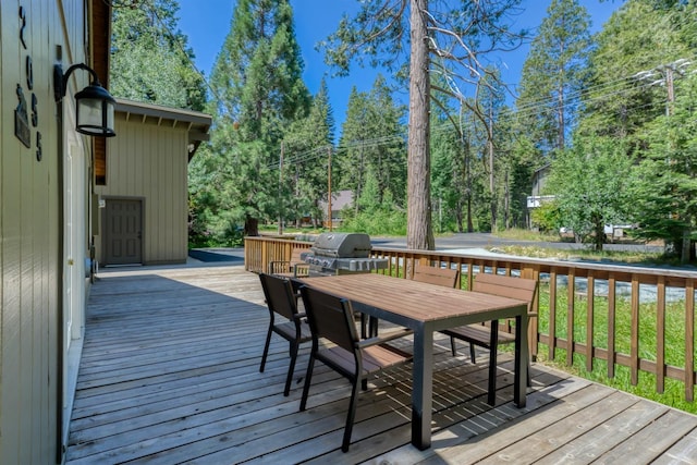 42055 Saddleback Rd, Shaver Lake, CA 93664 - deck with outdoor dining space, area for grilling, and view of wooded area