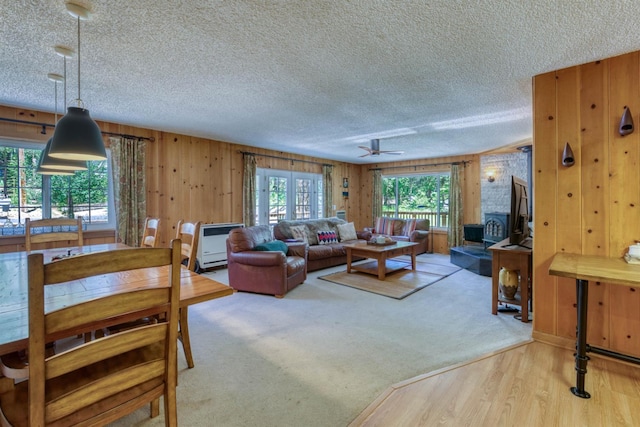 42055 Saddleback Rd, Shaver Lake, CA 93664 - living area featuring a textured ceiling, wooden walls, ceiling fan, and wood finished floors