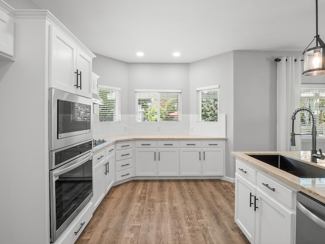 180 N Anderson Ave, Clovis, CA 93612 - kitchen with appliances with stainless steel finishes, recessed lighting, light wood-style floors, tasteful backsplash, and white cabinetry