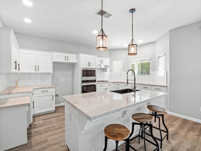 180 N Anderson Ave, Clovis, CA 93612 - kitchen with appliances with stainless steel finishes, under cabinet range hood, decorative backsplash, recessed lighting, and light wood-type flooring