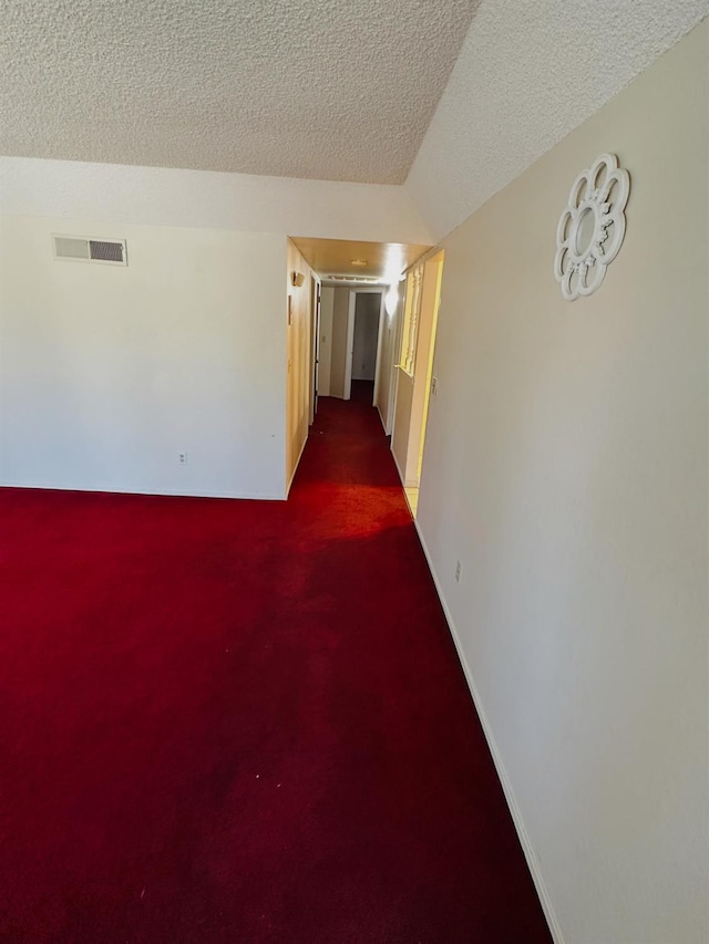 3043 N Brunswick Ave, Fresno, CA 93722 - corridor with dark carpet and a textured ceiling