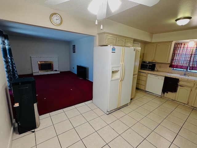 3043 N Brunswick Ave, Fresno, CA 93722 - kitchen with white appliances, tile countertops, light tile patterned floors, a ceiling fan, and a fireplace