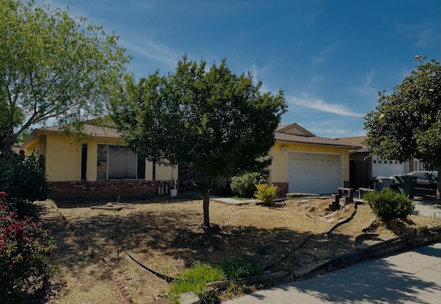 3043 N Brunswick Ave, Fresno, CA 93722 - obstructed view of property with brick siding, an attached garage, and stucco siding