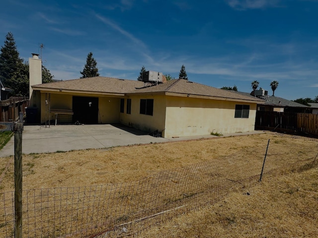 3043 N Brunswick Ave, Fresno, CA 93722 - back of property with a patio, a fenced backyard, stucco siding, and a chimney