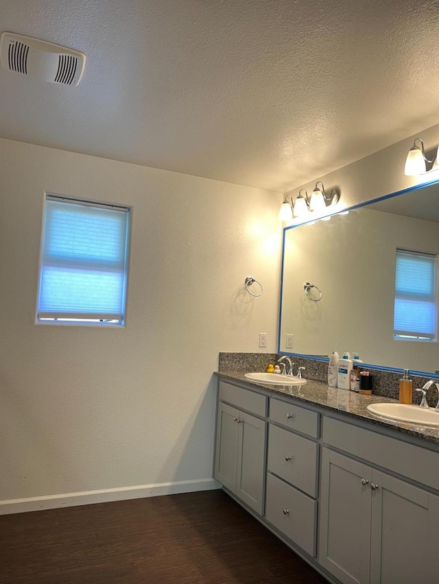 4542 N Casey Ave, Fresno, CA 93723 - bathroom with double vanity, wood finished floors, and a textured ceiling