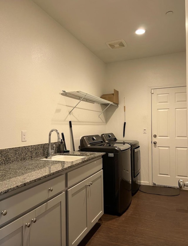 4542 N Casey Ave, Fresno, CA 93723 - washroom featuring washing machine and clothes dryer, dark wood finished floors, and cabinet space
