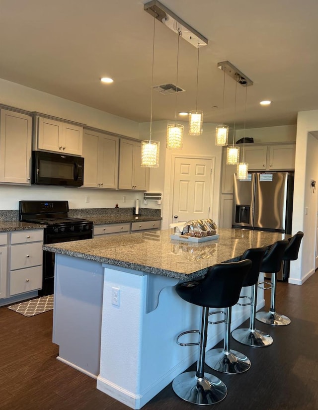 4542 N Casey Ave, Fresno, CA 93723 - kitchen featuring black appliances, dark stone counters, a center island, dark wood finished floors, and recessed lighting