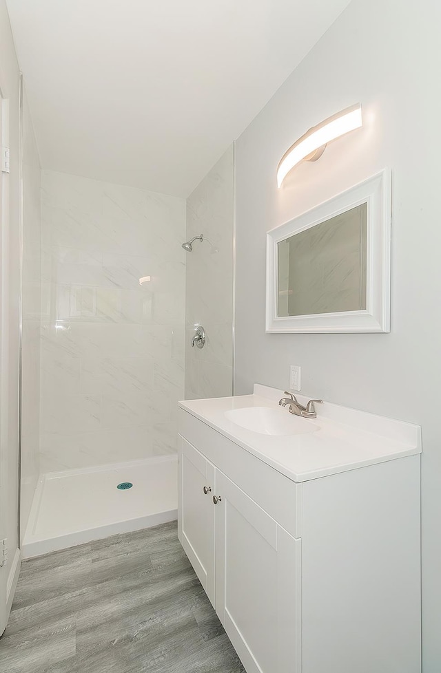 6683 N Spalding Ave, Fresno, CA 93710 - bathroom with vanity, tiled shower, and wood finished floors