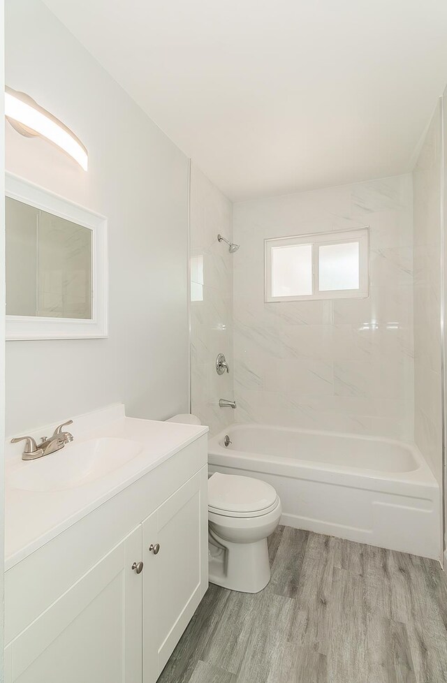 6683 N Spalding Ave, Fresno, CA 93710 - bathroom featuring vanity, wood finished floors, and shower / bathtub combination