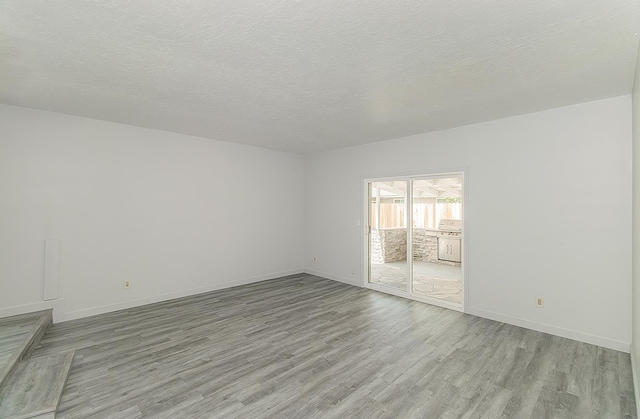 6683 N Spalding Ave, Fresno, CA 93710 - unfurnished room featuring light wood-type flooring and a textured ceiling