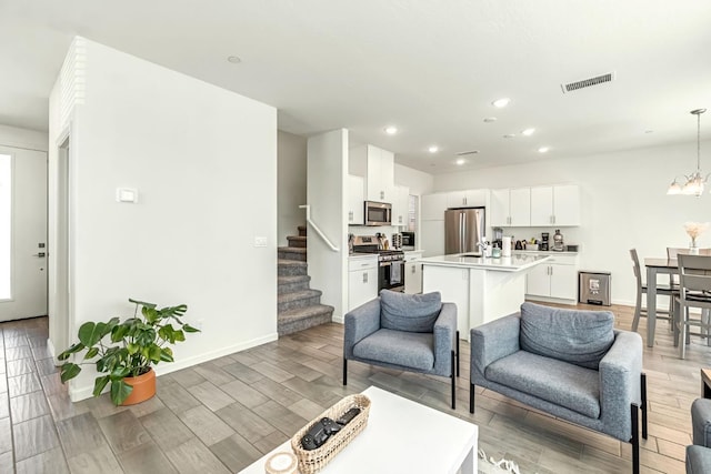 2047 N Ralph Ln, Clovis, CA 93619 - living area with stairs, light wood-type flooring, a chandelier, and recessed lighting