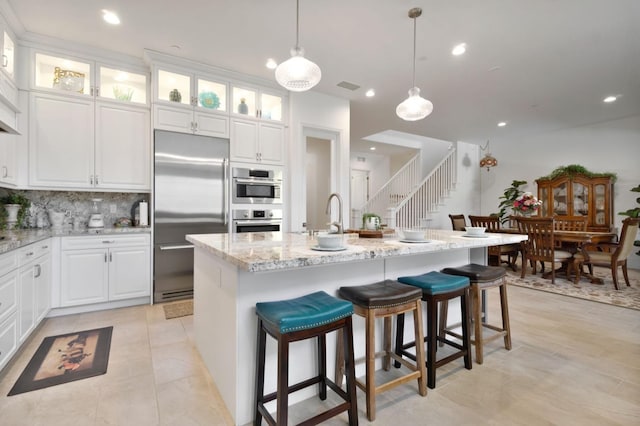 4693 Del Oro Rd, Madera, CA 93636 - kitchen featuring appliances with stainless steel finishes, recessed lighting, tasteful backsplash, light stone counters, and decorative light fixtures