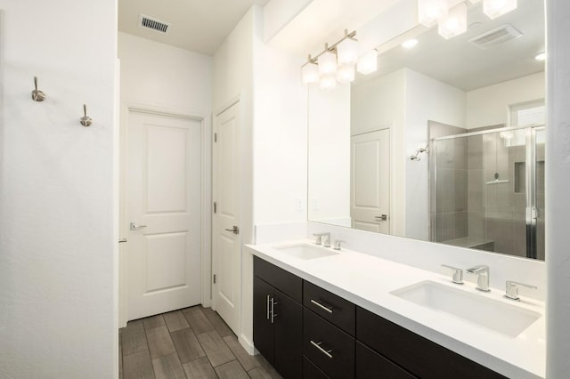 644 Atlantica Dr S, Madera, CA 93636 - bathroom with double vanity, a shower stall, and wood finished floors
