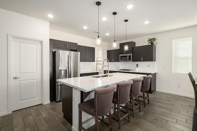 644 Atlantica Dr S, Madera, CA 93636 - kitchen with stainless steel appliances, wood finish floors, light countertops, a kitchen breakfast bar, and recessed lighting