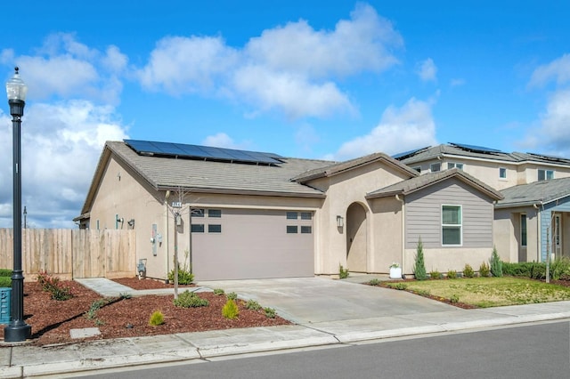 644 Atlantica Dr S, Madera, CA 93636 - view of front of house featuring stucco siding, a garage, concrete driveway, and solar panels