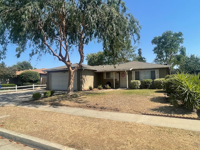 3317 W Indianapolis Ave, Fresno, CA 93722 - ranch-style home with an attached garage, driveway, and stucco siding